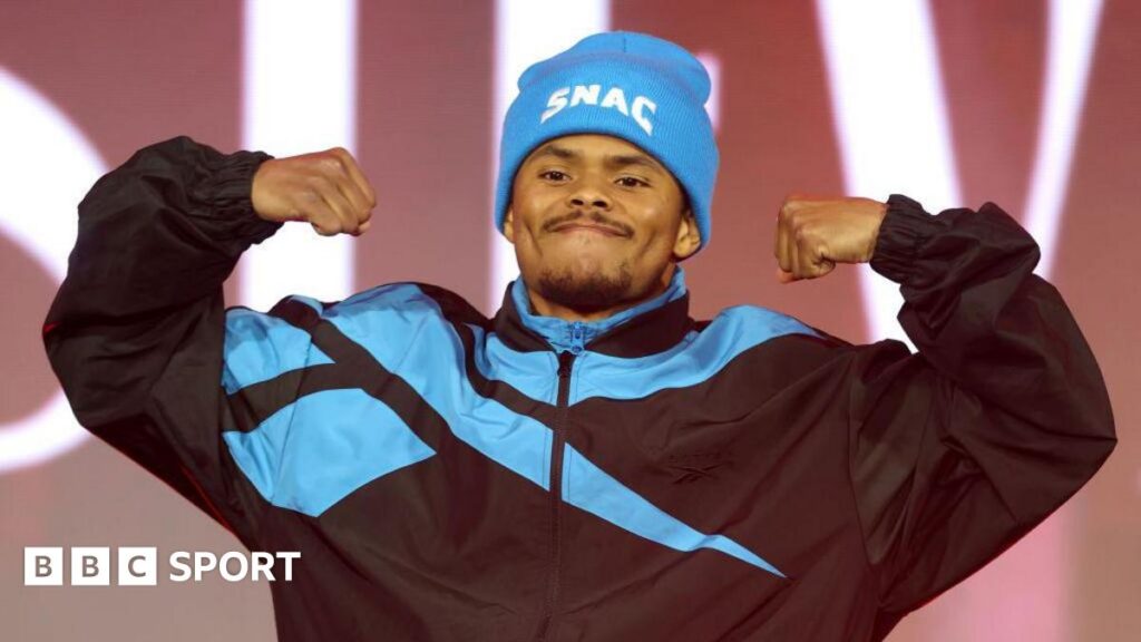 Wearing a light blue hat and black tracksuit, Shakur Stevenson flexes