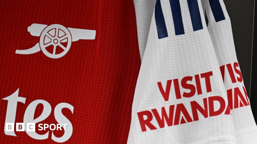 Detail of a red and white Arsenal shirt, with the Visit Rwanda on the sleeve